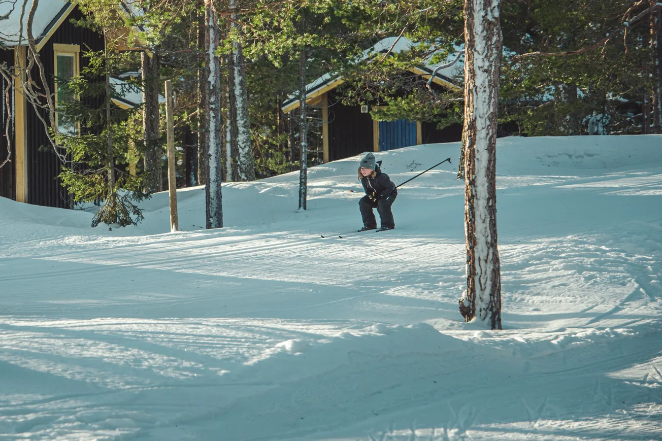 En person på skidor i snön nära några träd.