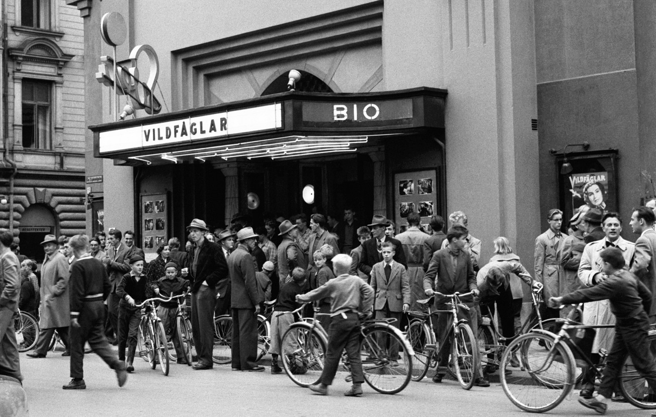 Fullt med folk utanför Sveabiografens entré. Flera har med sig sin cykel.