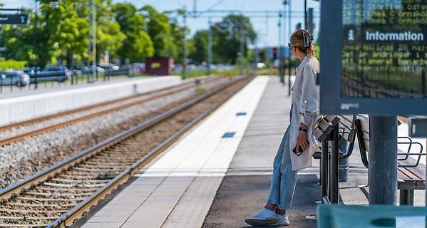 Kvinna väntar på tåget.