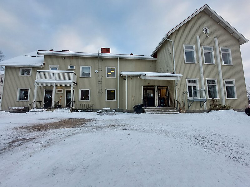 Ett stort skolhus i vintermiljö.